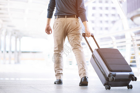 商业旅行者在现代机场候舱行李业务中拖着箱的车客商务旅者在现代机场终点站行李业务中游客飞机泰国图片