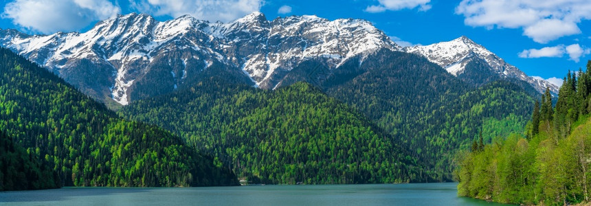 高加索山脉美丽的里察湖青山丘陵蓝天白云春风景全森林路易丝绿图片