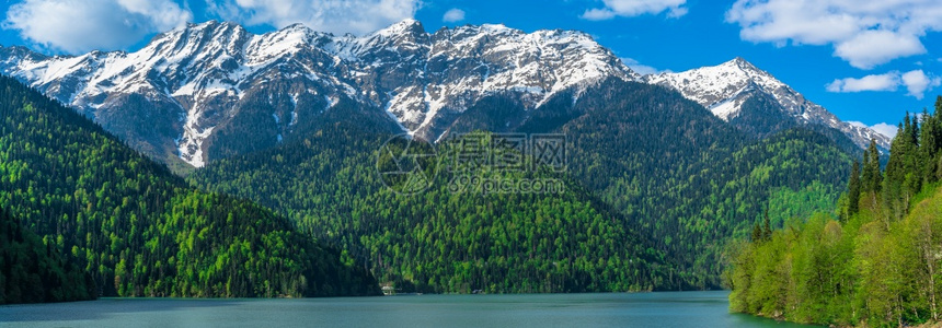 高加索山脉美丽的里察湖青山丘陵蓝天白云春风景全森林路易丝绿图片