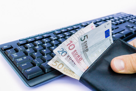 金融收益在白背景孤立的键盘上手持带欧元钱币的包银行业图片