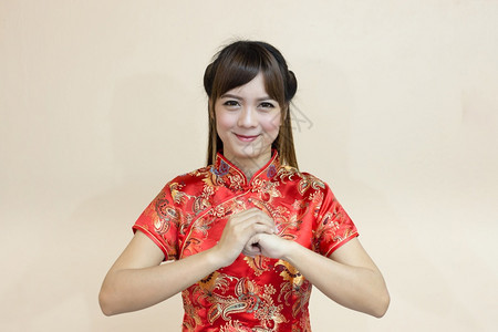 亚裔妇女以传统的中文或青相语向亚洲妇女打贺礼手举欢迎表情幸运地在新年庆祝红金式的人节日走运年轻的红色喜悦图片