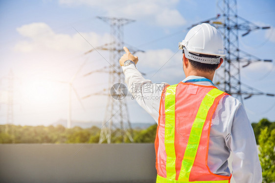 植物环境电动工程师站在手举起天高电压杆背景的手顶上检查员图片