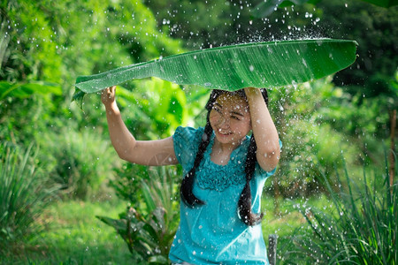 植物美丽在绿花园背景下雨时一位年轻亚洲女身着香蕉叶的黑头发肖像年轻的图片