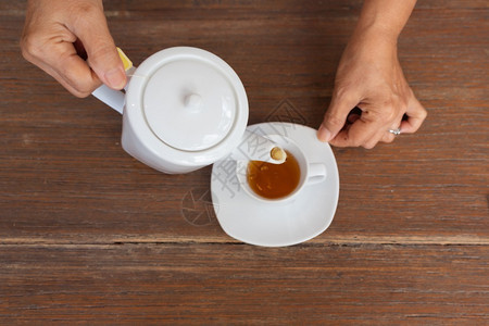 木桌上泡茶的雌风景白色喝餐具图片