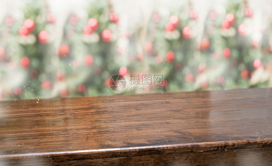 复制含有抽象模糊的圣诞树红色装饰舞会和雪落背景的木板桌顶上面有抽象模糊的圣诞树红装饰球和雪秋幕背景带有bokeh灯光冬假日背景挂图片