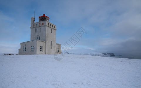 Dyrholaey角灯塔全景图像冰雪和清晨光照冰岛冬季日出乡村的户外图片