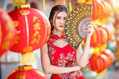 秋天亚洲年轻女子身着传统红青山装饰并拿着纸灯为神庙新年庆典举办风光节行盛会的中华少女长相微笑脸范宁图片
