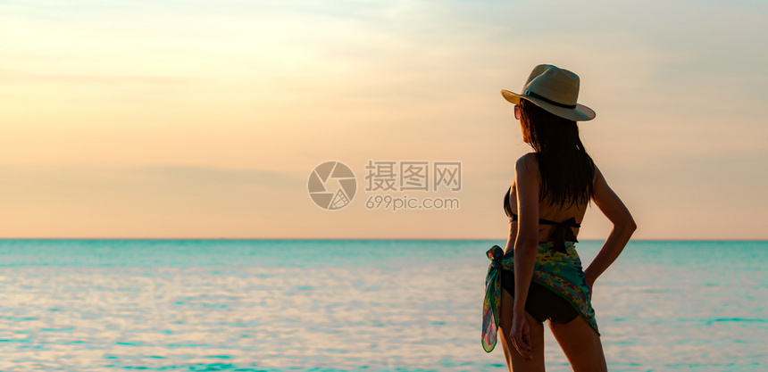 女子在海边享受日落风景图片