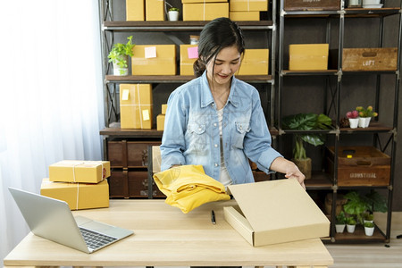 交货纸板幸福表格上的妇女包装箱检查向亚洲女客户的妇托运货物包装交付物的情况在主办公台服务开小企业家将产品包装成送货图片