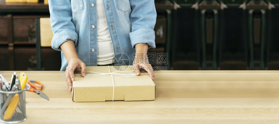 办公室表格上的妇女包装箱检查向亚洲女客户的妇托运货物包装交付物的情况在主办公台服务开小企业家将产品包装成送货查看为了图片