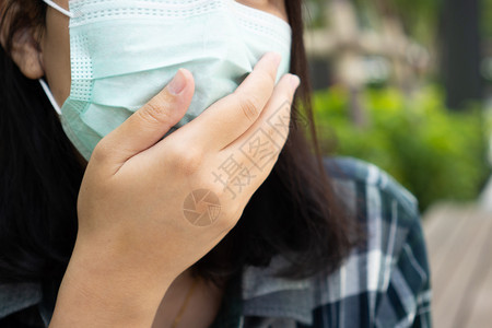 户外戴口罩防止污染的女性特写图片