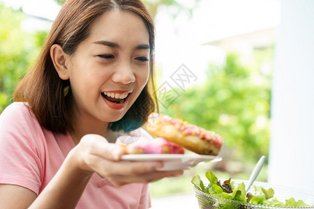 美丽的亚洲健康中年女乐于吃甜圈因为很久没有吃过饭因为它希望健康概念保和营养食品的医疗保健和营养食品笑声掌食物陈年糖图片
