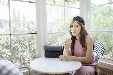 亚洲人活动笑的亚洲年轻女笑脸喝着凉爽一瓶绿茶饮料成人图片
