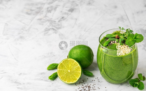 水果以香蕉石灰芝麻和种子及微绿色制成的菠菜冰雪在玻璃杯面上贴复制空间生的态图片