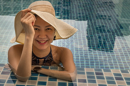 戴帽子的年轻女士在顶户外游泳池放松享受阳光明媚的假日暑概念蓝色的最佳女图片