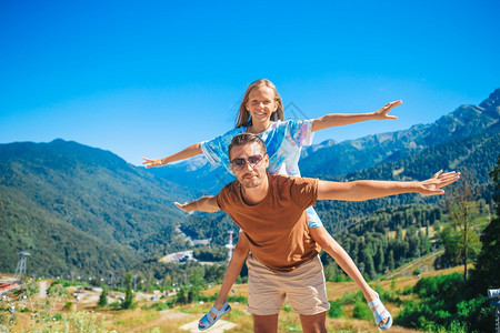 山上快乐的父亲和小女孩家庭在暑假的山上美丽幸福家庭在山上背景中的美丽幸福家庭索契聚胺景观图片