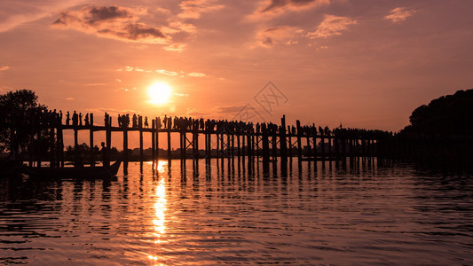 日落时分在UBein桥上行走的人休光片晚上丰富多彩的太阳图片