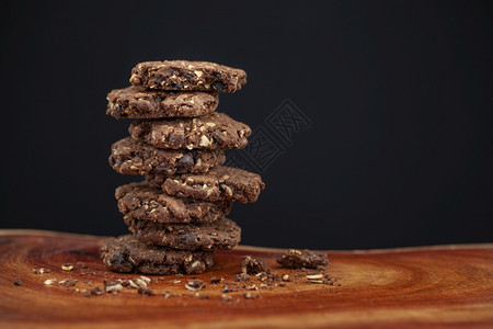 塔棕色的黑暗背景天然木质料选择焦点上的巧克力芯片和橡皮饼干有选择的重点图片
