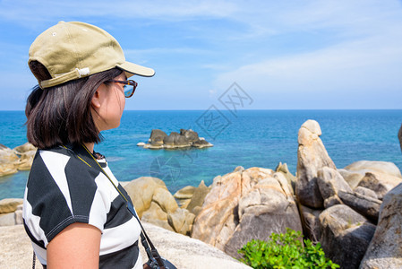 地标夏天风景优美年轻女游客在泰国苏拉特萨尼KohSamui岛夏季旅游时正站在HinTaHinYai和蓝色海天空美丽的自然景观旁着图片