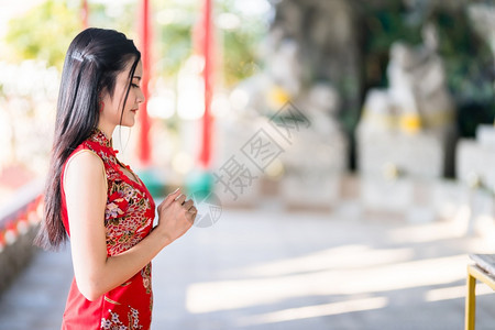 宗教的身着青山传统红衣装饰的亚洲美丽年轻女坐在泰国华神庙新年节布达雕像祈祷仪式上庆典东方的图片