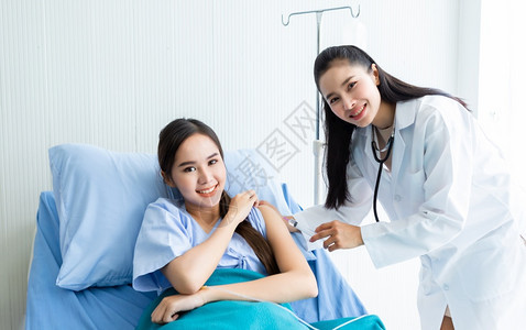 年轻女医生用注射器给女病人手臂注射治疗图片