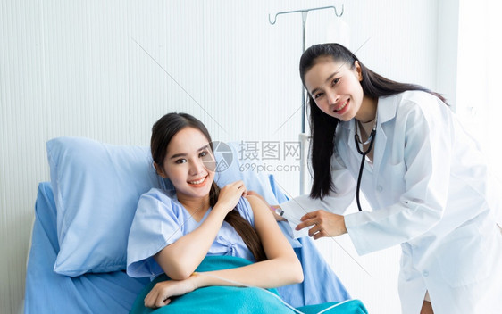 年轻女医生用注射器给女病人手臂注射治疗图片