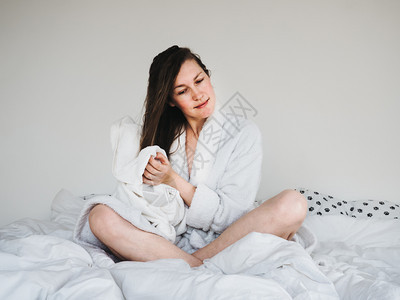 模型浴室卧漂亮年轻的女人穿着柔软特里的浴袍梳理她头发后SpaSpaServices和Spa治疗图片