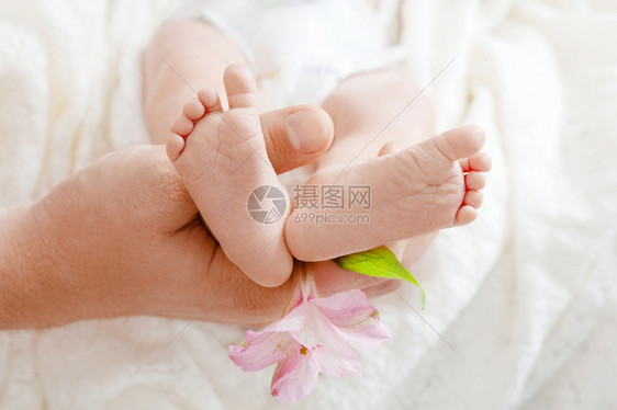 保护家长父母亲手握在新生婴儿的脚下Tiniy新生儿Birrsquos双脚举手紧妈和她的孩子幸福家庭概念童年图片