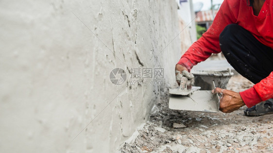 改进工作程建筑地房用墙上石膏水泥的工人手印图片