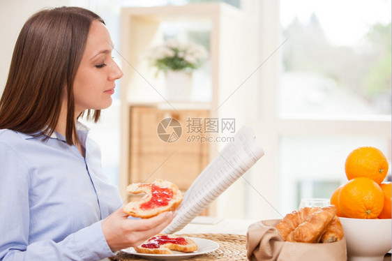 一顿饭布朗特女商人在家吃早餐时正看报纸保持国内的图片