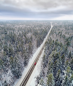 景观冬季森林中雪覆盖道路的空中景象冬季天气过日汽车经风景优美下雪的图片