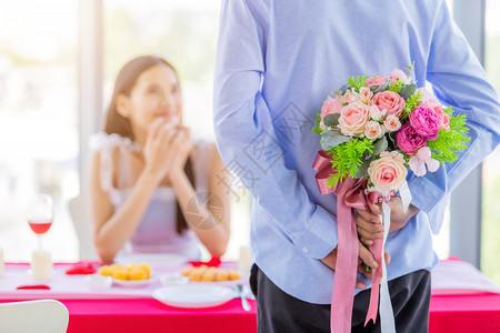 年轻的结束一个男人亚洲一个男拿着束玫瑰花手放在脸上的女人午餐后等待惊喜在餐厅背景中ChlooseofAsian庆典女士图片