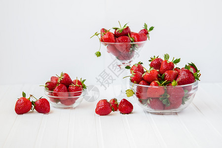 从你的花园收获健康地吃红成熟的草莓概念在你花园里用玻璃碗吃红成熟的草莓在你花园里用白木板桌子上摘取果实从你的花园里摘取有机的团体图片