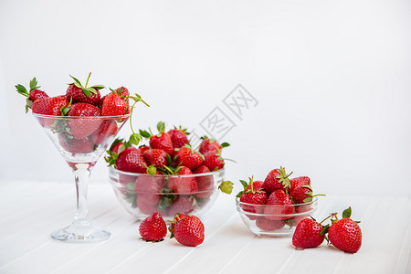 菜肴新鲜从你的花园收获健康地吃红成熟的草莓概念在你花园里用玻璃碗吃红成熟的草莓在你花园里用白木板桌子上摘取果实从你的花园里摘取食图片