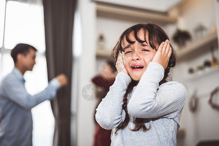 争论女孩因父母吵而哭泣因为她父母争吵女孩被虐待母亲和父在家中大喊冲突激怒背景的家庭戏剧场景家庭社会问题概念情绪化的福利图片