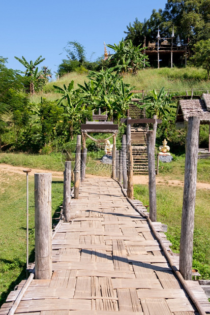 旅游老的哪一个旧竹桥目地越过农村庄稻田到位于泰国北部公共区ThaiPublic地区山丘上的方庙宇不需要财产放行在泰国公共区北面的图片