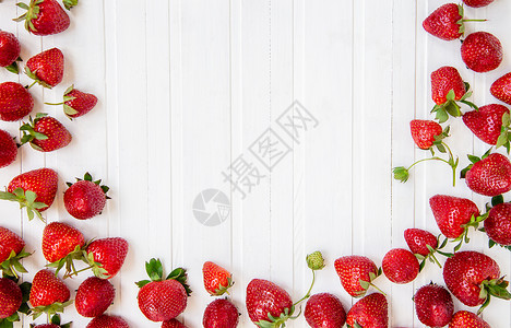 甜的成熟红草莓散落在白色的木桌上背景有草莓文本的地方成熟红草莓散落在白色的木桌上背景有草莓食物维他命图片