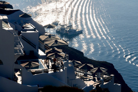 天空希腊圣托里尼火山口之夜太阳背光下的房屋和露台在锚地航行的游艇圣托里尼火山口的背光房屋和停泊的游艇海传统图片