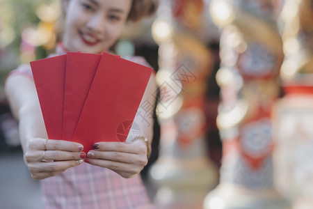 服装幸福的亚裔女人拿着红包在月露新年给阿宝做安啦新年快乐的概念农历吸引人的背景图片