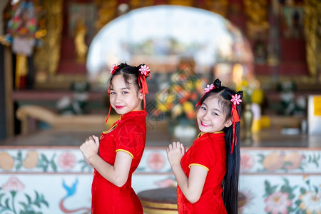 女士文化身着中华新年节国青春红传统香装饰的可爱小亚裔两个女孩长得漂亮美丽的笑脸亚洲人图片