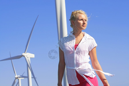 涡轮循环活力年轻女子梦想着未来在叶左发电机下的风力农场上图片