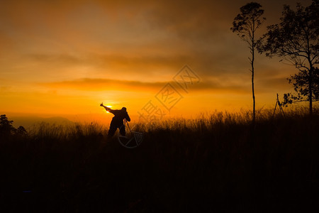 服用拍摄日落时风景照片的摄影记者周光片森林谷图片