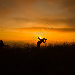 拍摄日落时风景照片的摄影记者周光片深的橙乡村图片