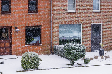 下雪的外部降荷兰一个小村庄的雪天寒冬冷的荷兰一个小村庄里有花园的现代dutch梯田式房屋图片
