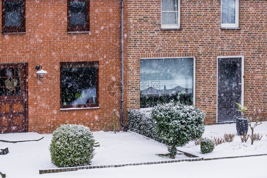 下雪的外部降荷兰一个小村庄的雪天寒冬冷的荷兰一个小村庄里有花园的现代dutch梯田式房屋图片