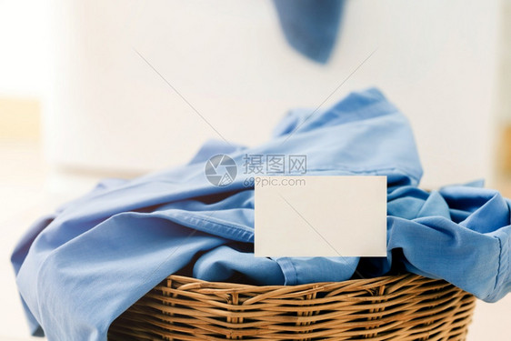 装有洗衣机背景涤的篮子衣服和白织物上紧贴空名片干净的折叠式纺织品图片