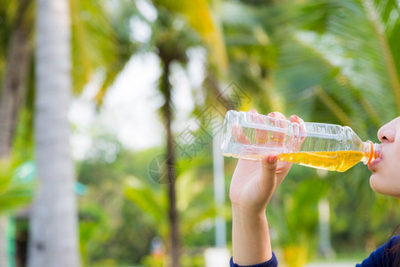 白种人妇女饮用绿色茶叶外出房间夏月背景带有绿色bokeh快乐的吸引人图片