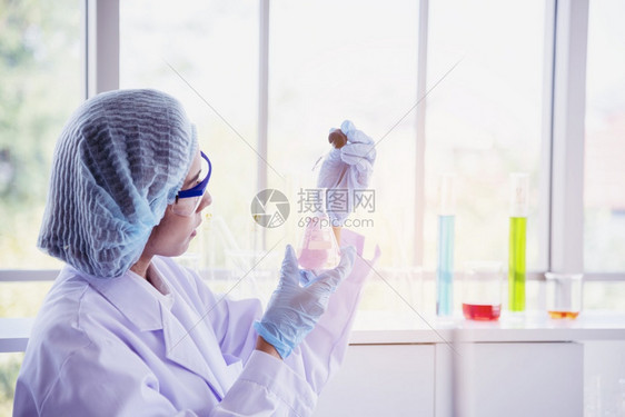 女科学家使用显微镜进行化学研究图片