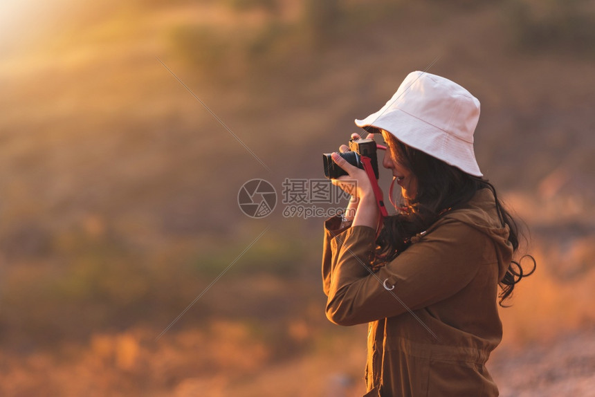 尽管景观美丽的女摄影师在户外旅行时戴着照相机的帽子手持相机在野外旅行时戴上相帽照片来自Flickr用户Twitter网站泰国图片