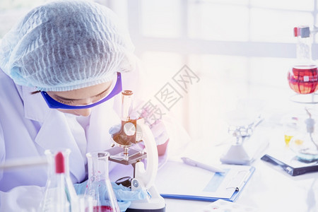学习明亮的人们女科学家看显微镜科学试管分析实验室研究中的科学样本生物技术制造抗疫苗化学科实验室概念图片